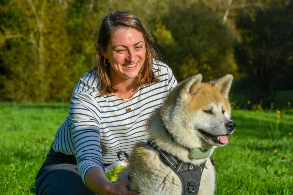 Justine, éducatrice canin, caresse un chien, Akita